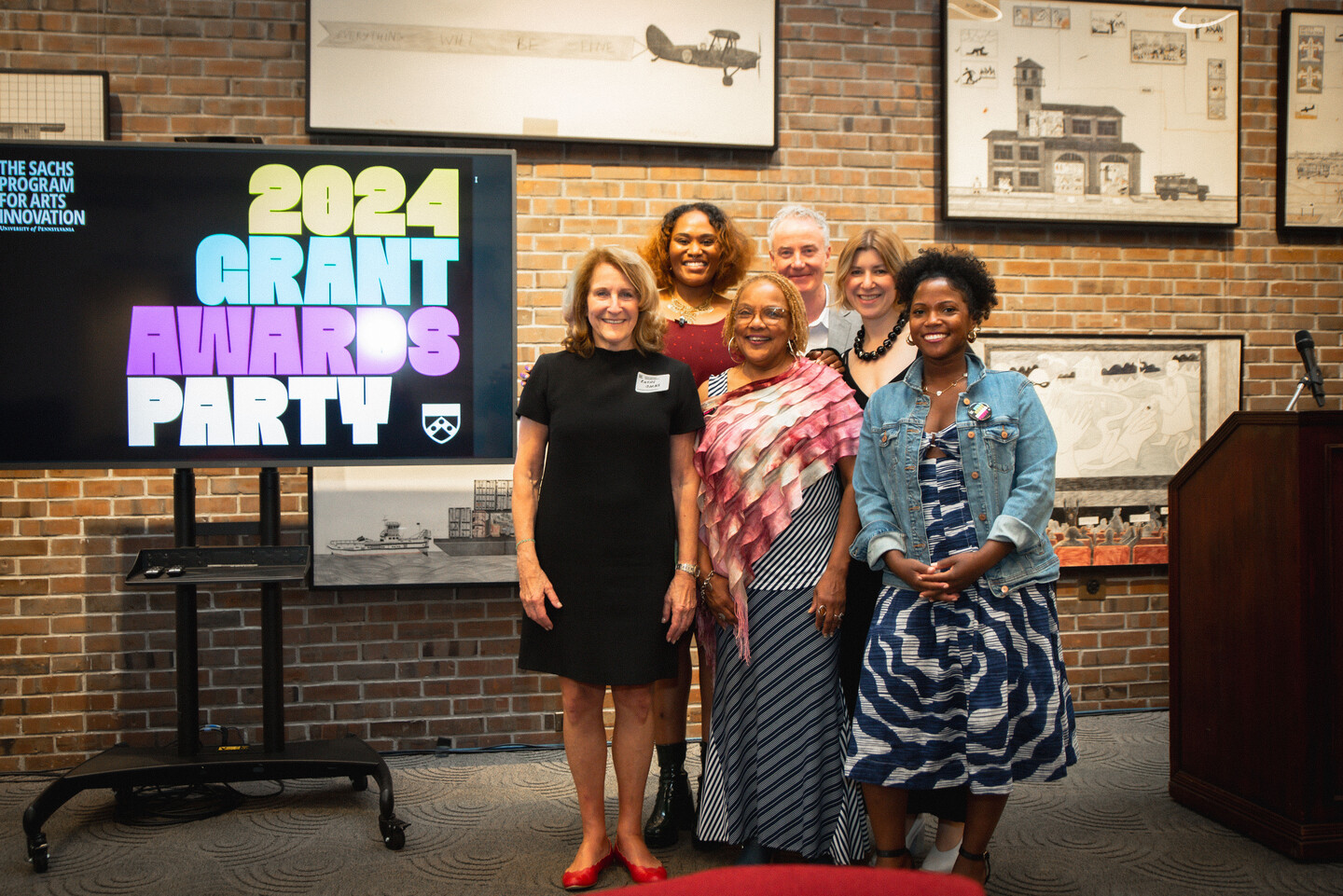 Sachs team and others pose for a photo in front of sign that reads 2024 Grant Awards Party.
