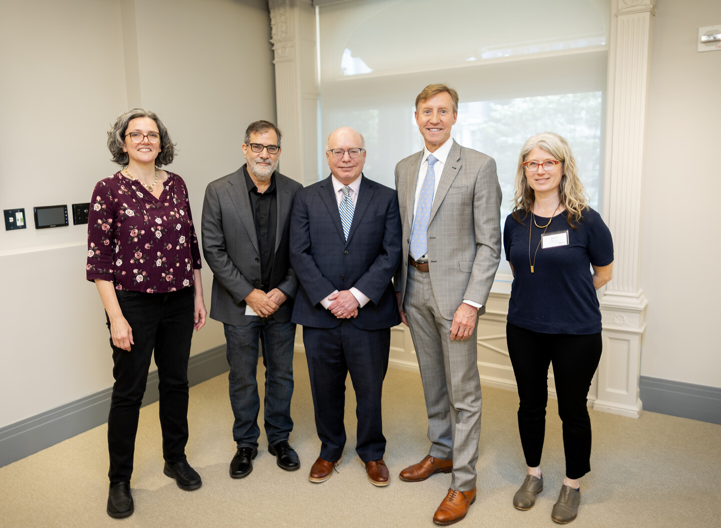 Penn President J. Larry Jameson poses with four other people inside the University Meeting and Guest House. 