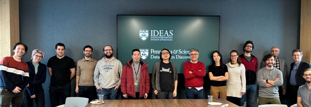 Group photo of researchers standing infront of a large monitor.