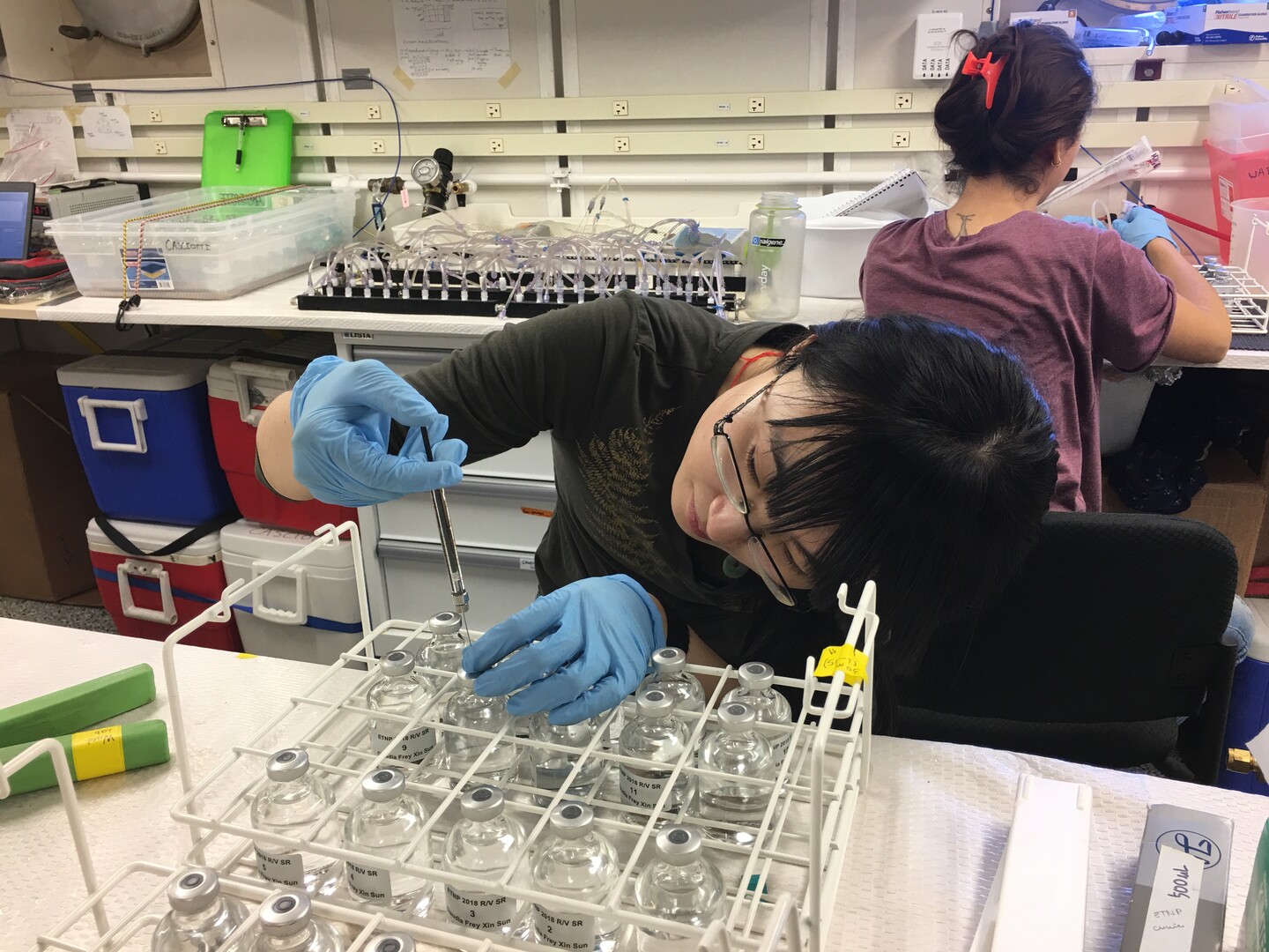 Researcher Xin Sun injects substance into glass vials.
