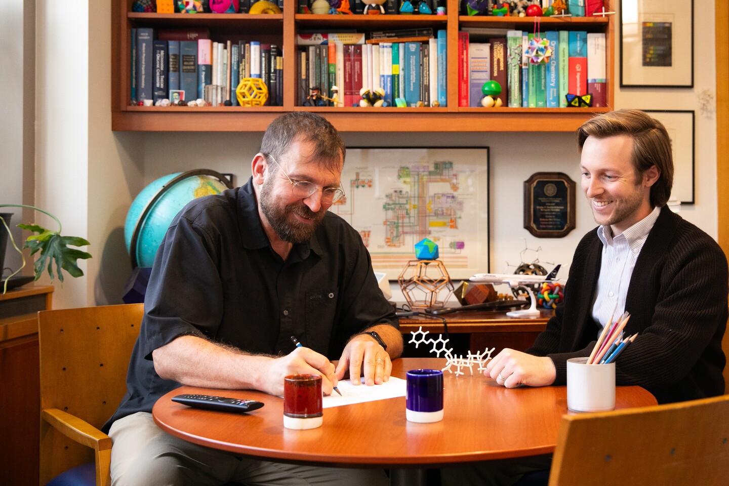 Dirk Trauner and Michael Zott seated at a desk.