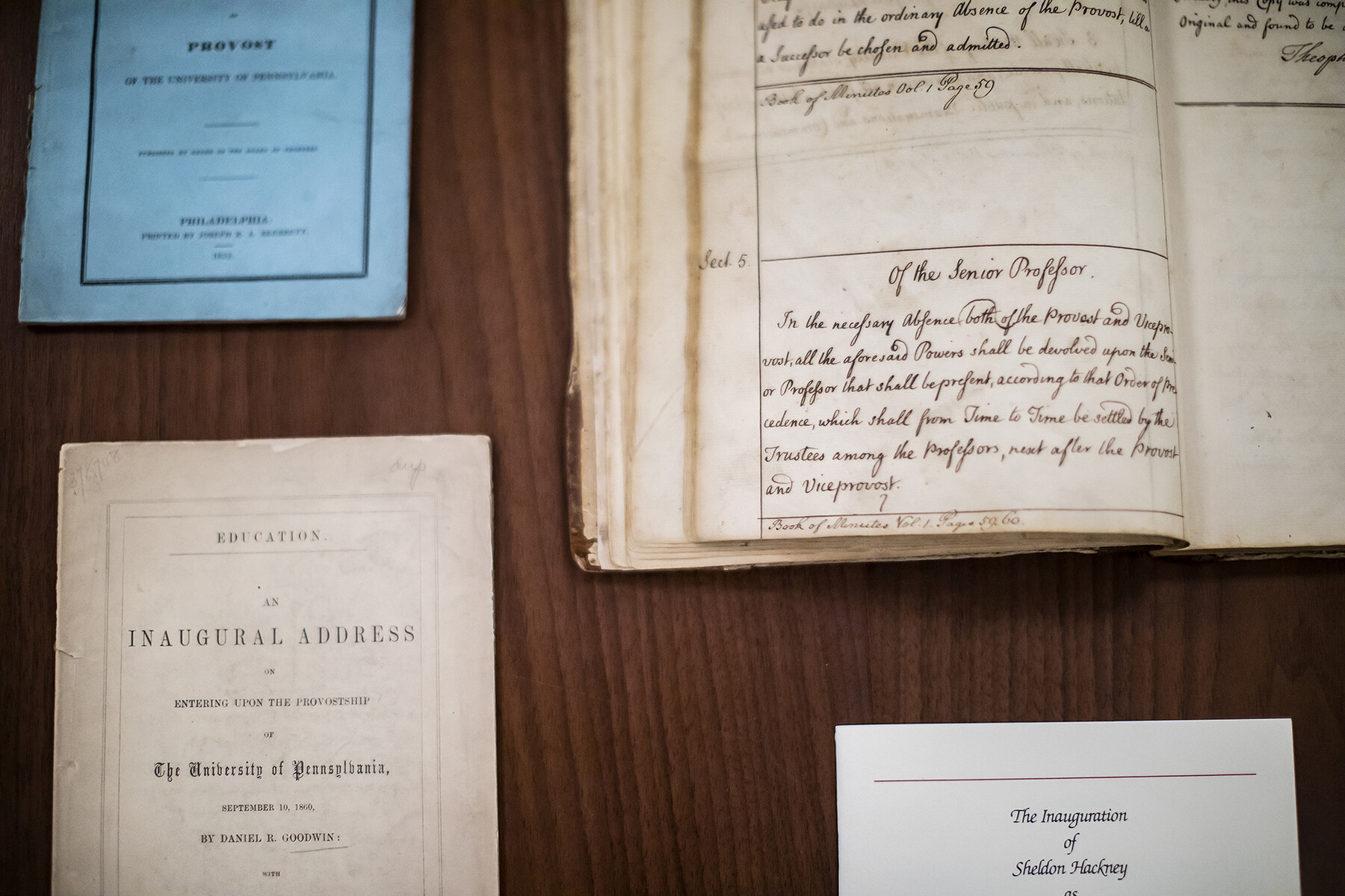 Open historical books and pamphlets from past Penn inaugurations on a table.