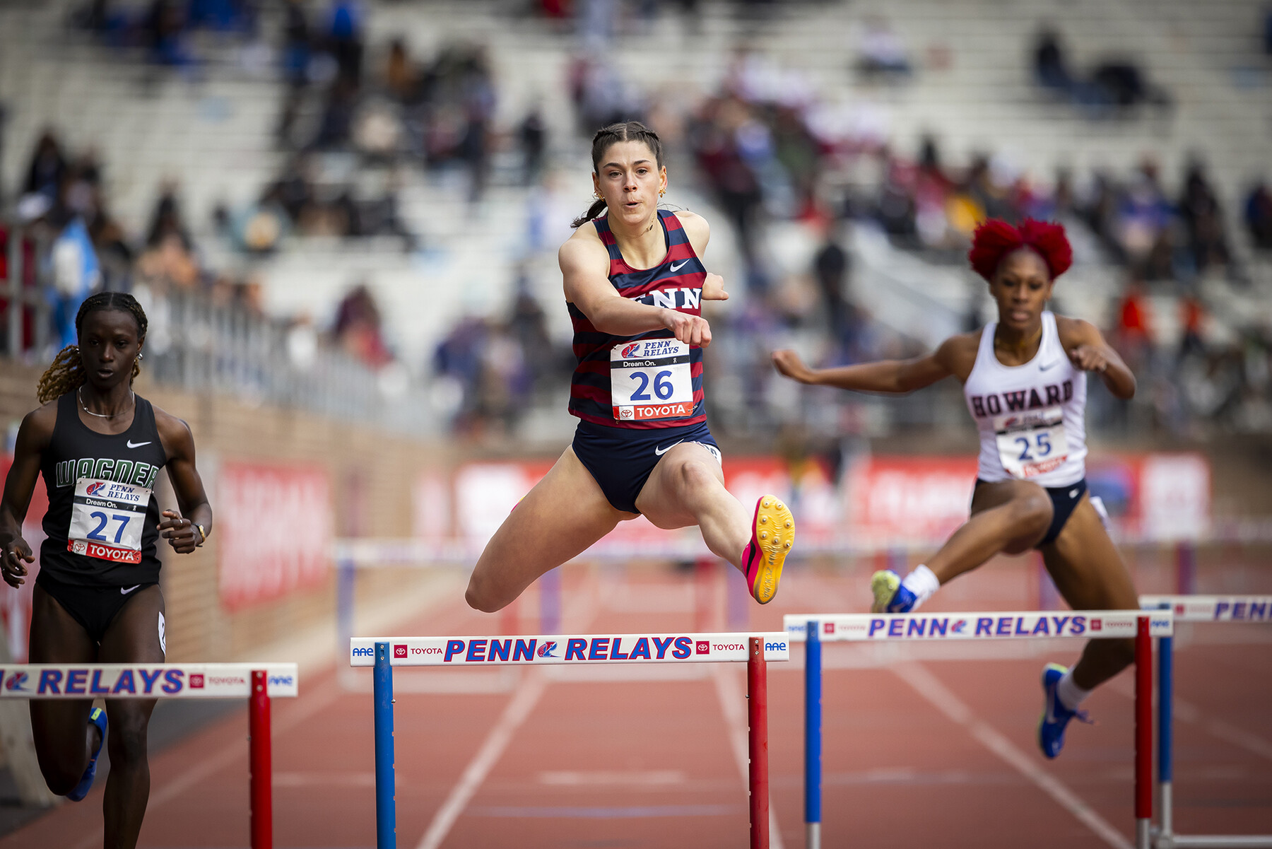 student athletes jump hurdles at the penn relays