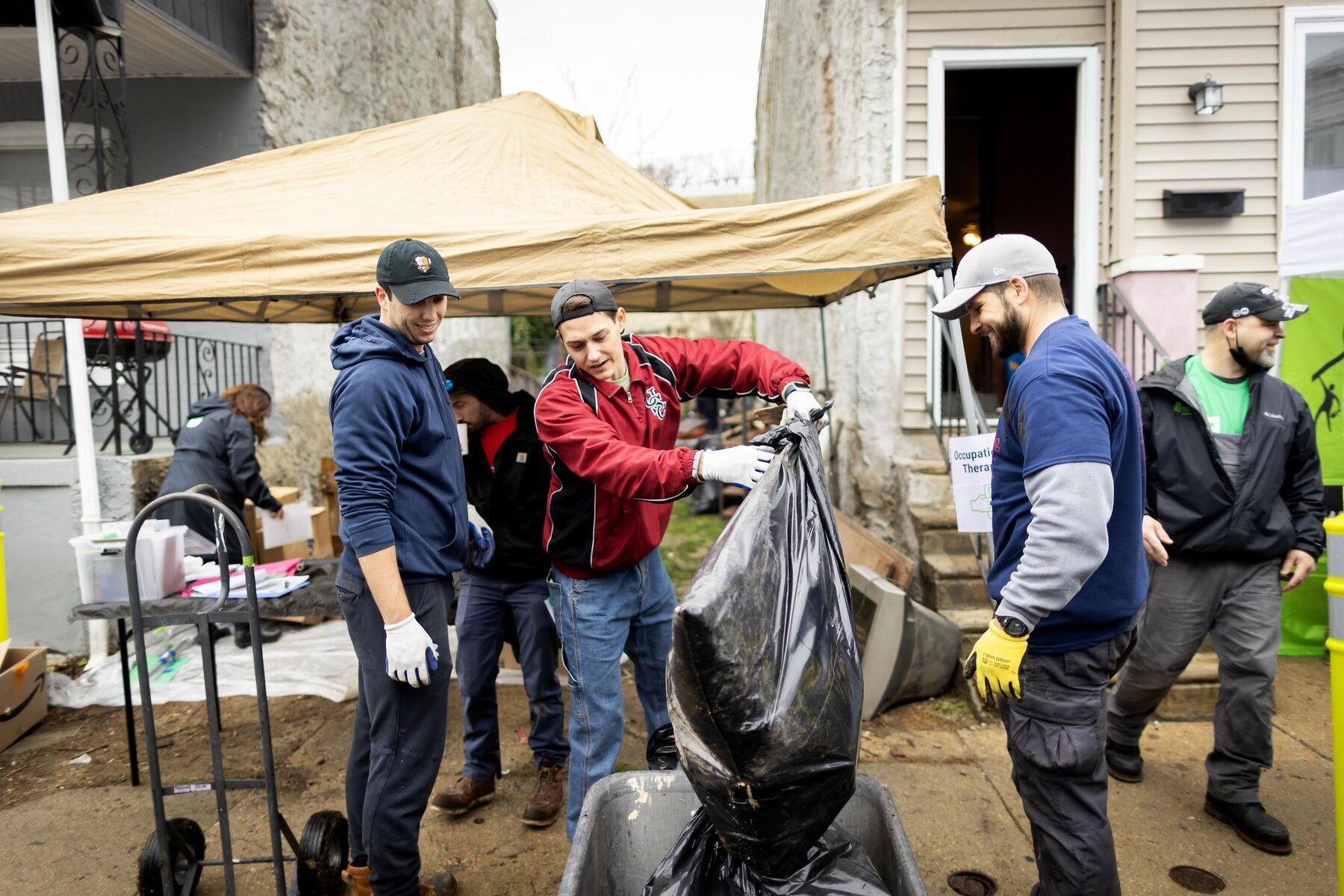 Volunteers lifting bags of waste outdoors during the block build.