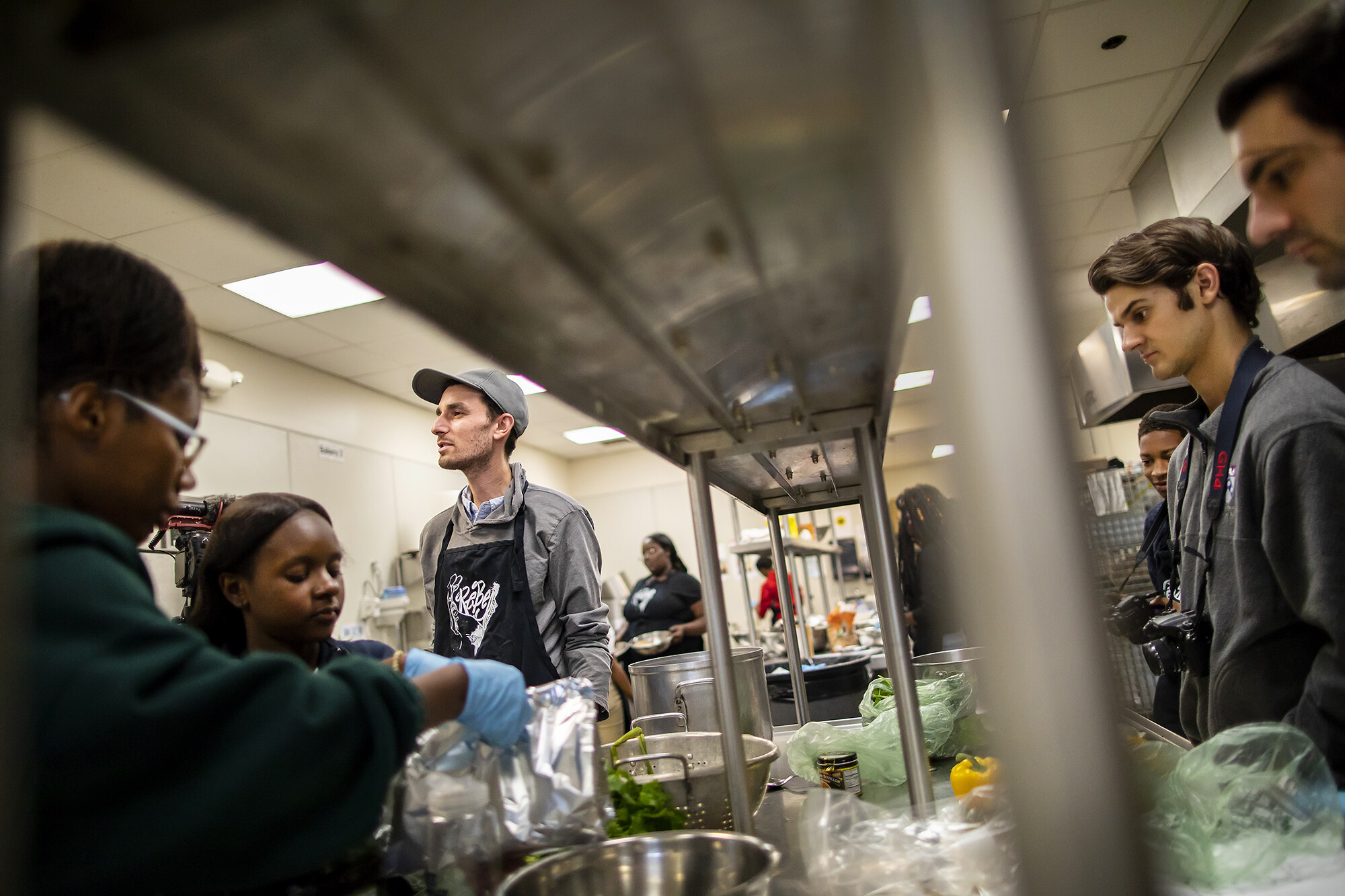 Jarrett Stein in a busy kitchen surrounded by people working on recipes