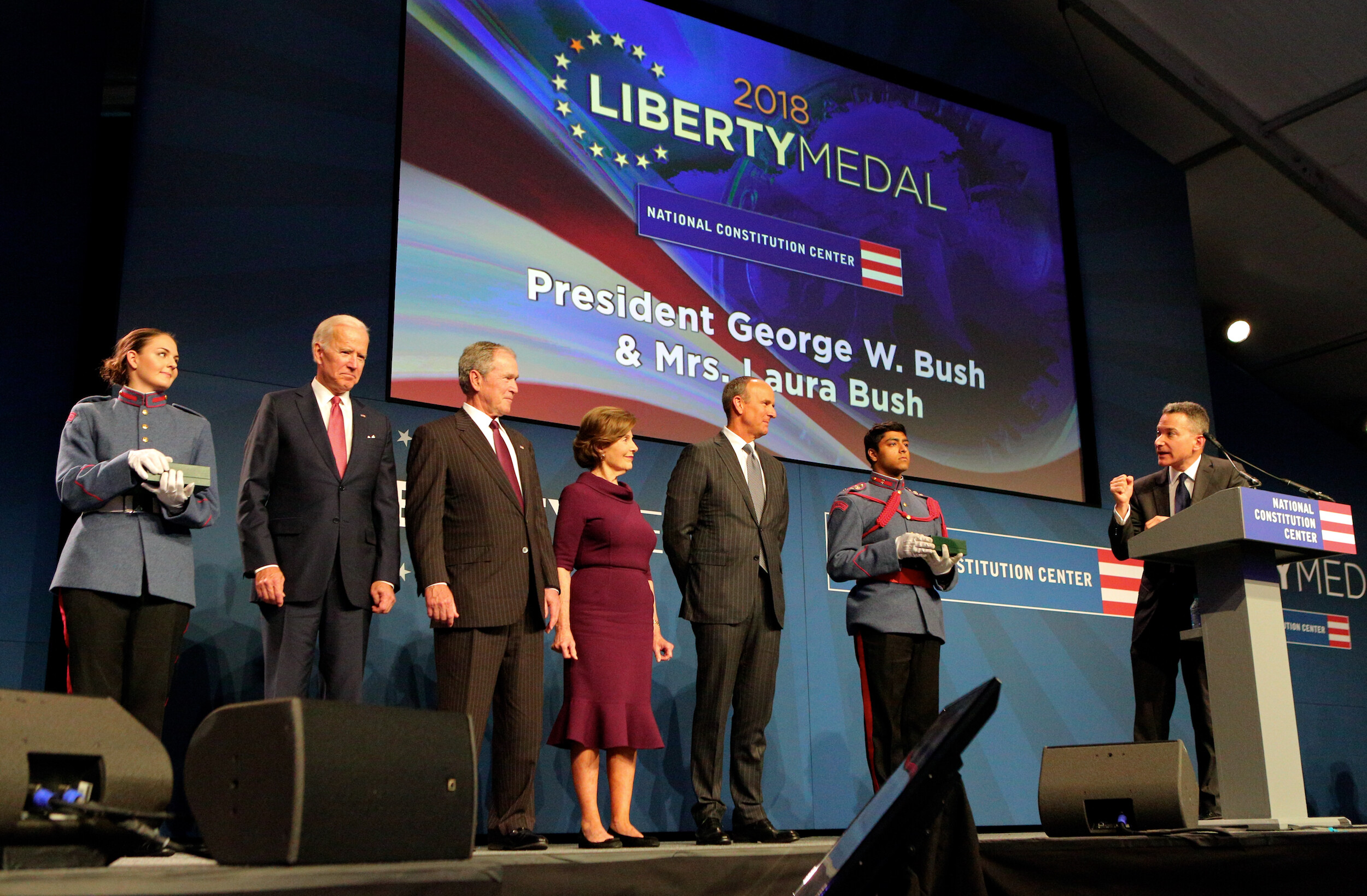 Liberty Medal honorees on stage being addressed by man at podium
