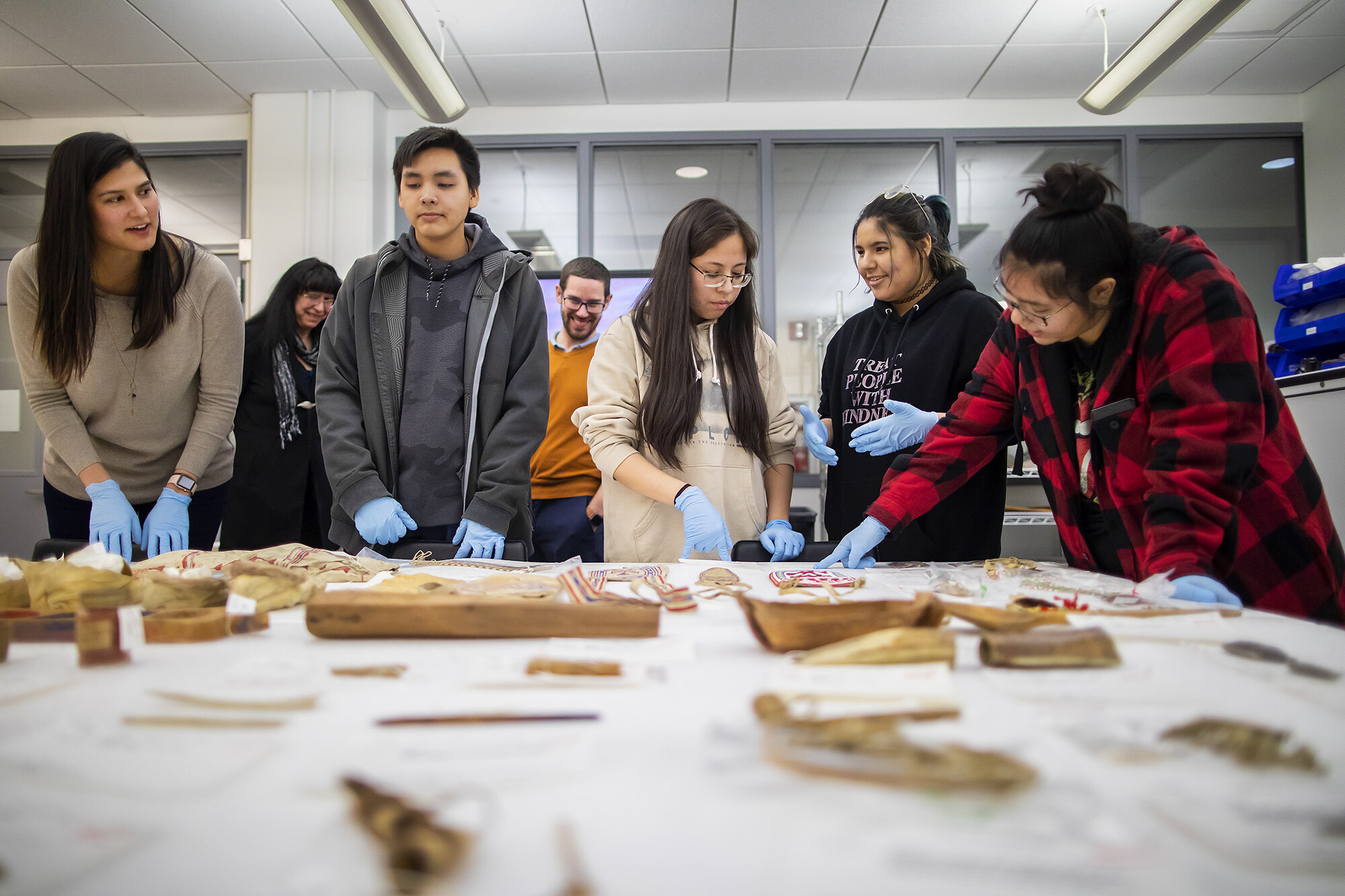 Students looking at Native American items on a table. 