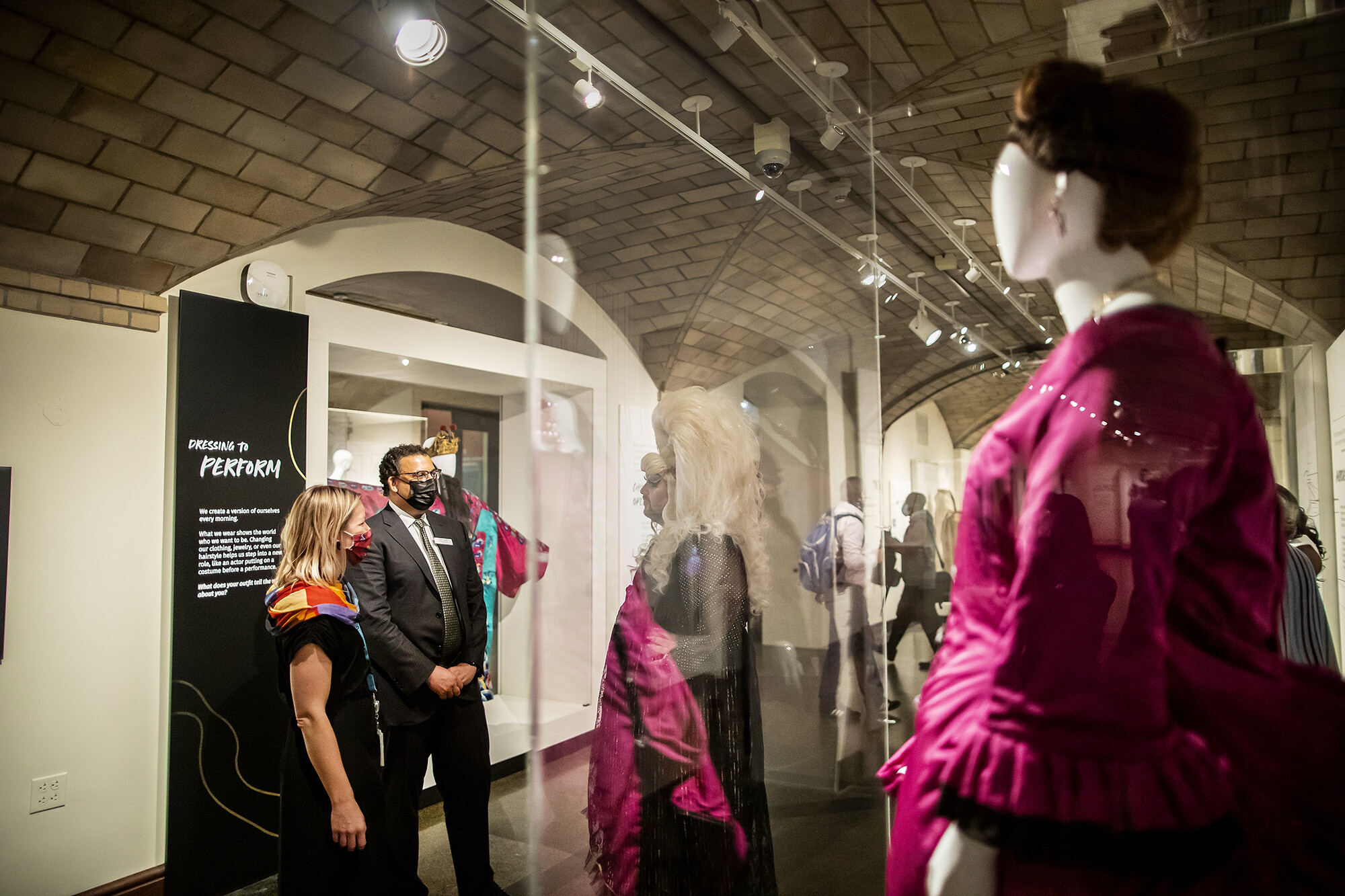 three people standing and talking in a museum gallery