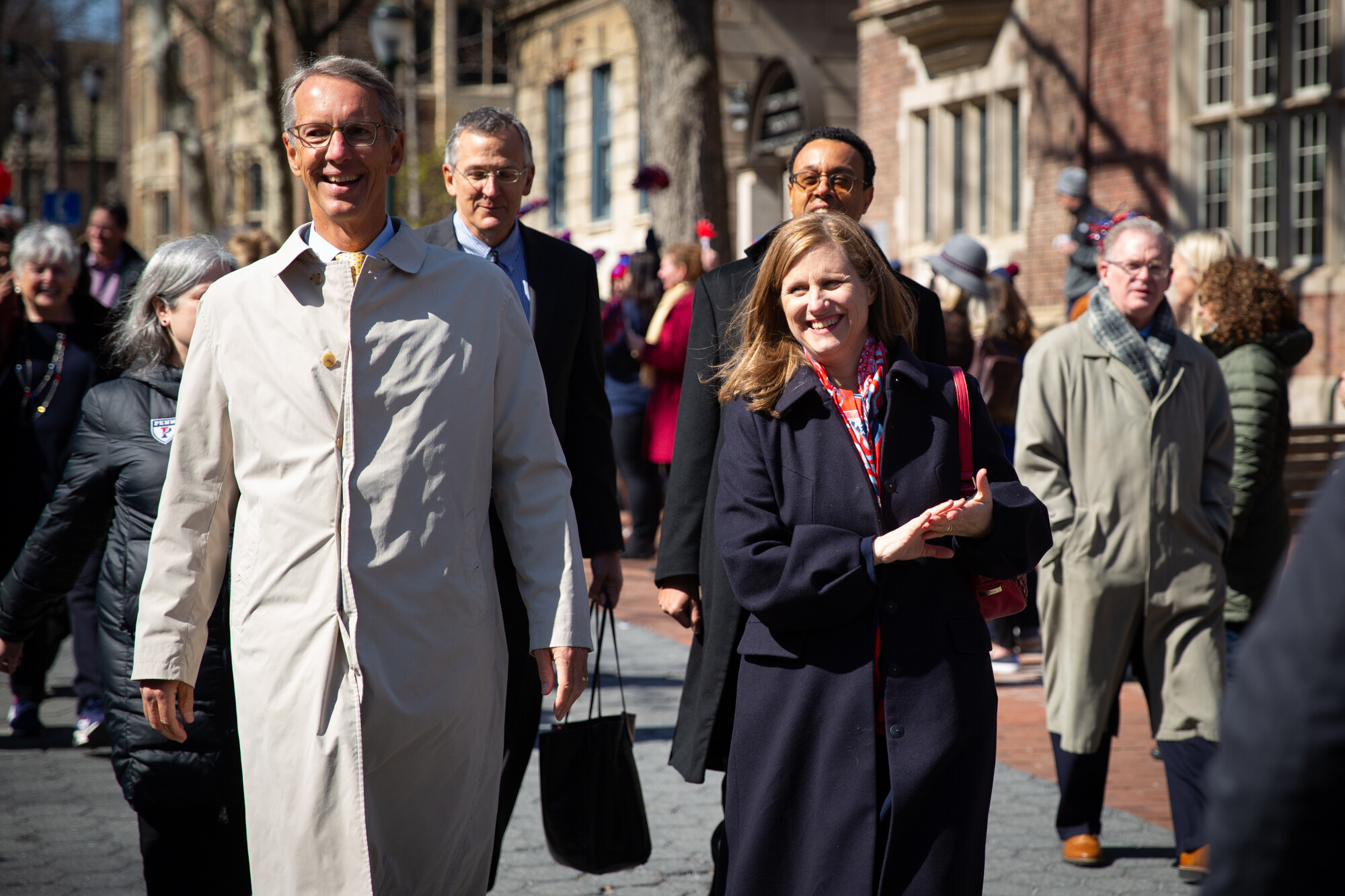 Scott Bok and Liz Magill walk in a crowd along Locust Walk.