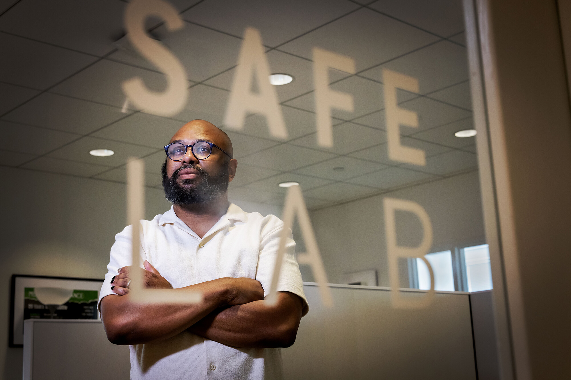 Desmond Patton behind an etched glass door reading "SAFElab"