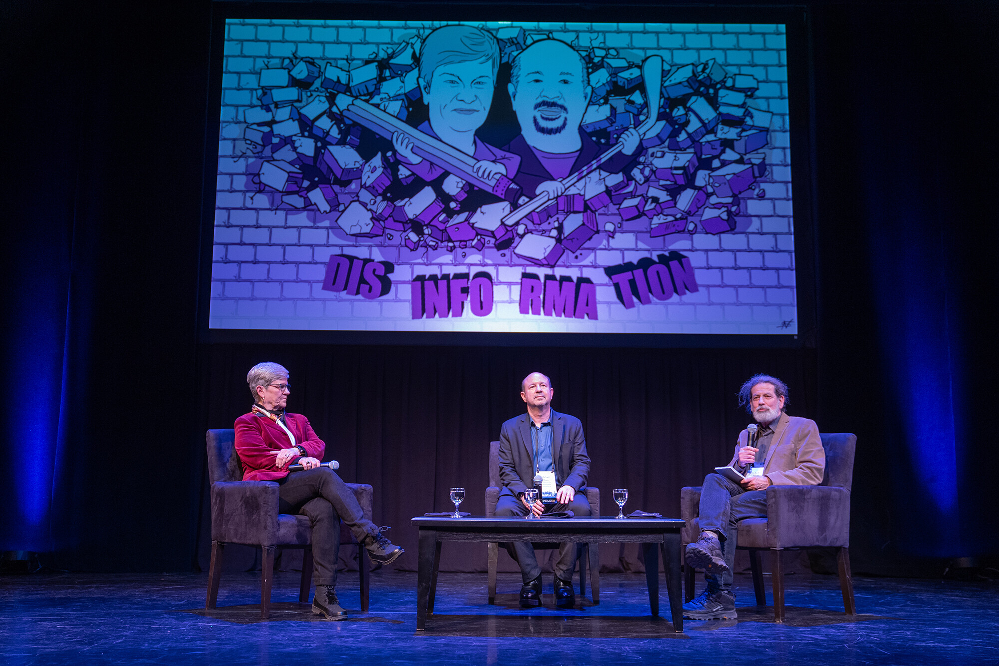 Kathleen Hall Jamieson, Michael Mann, and Rick Weiss seated on stage at an event.