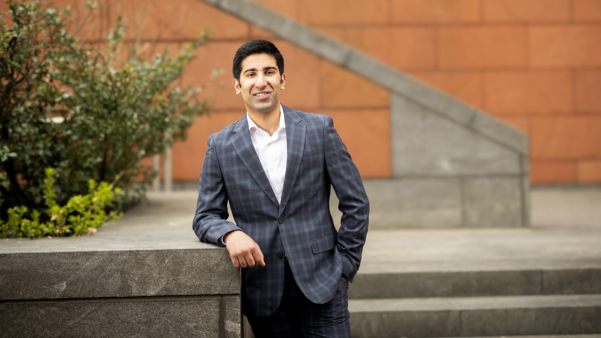Ayaan Jeraj wears a suit while standing outside Huntsman Hall.