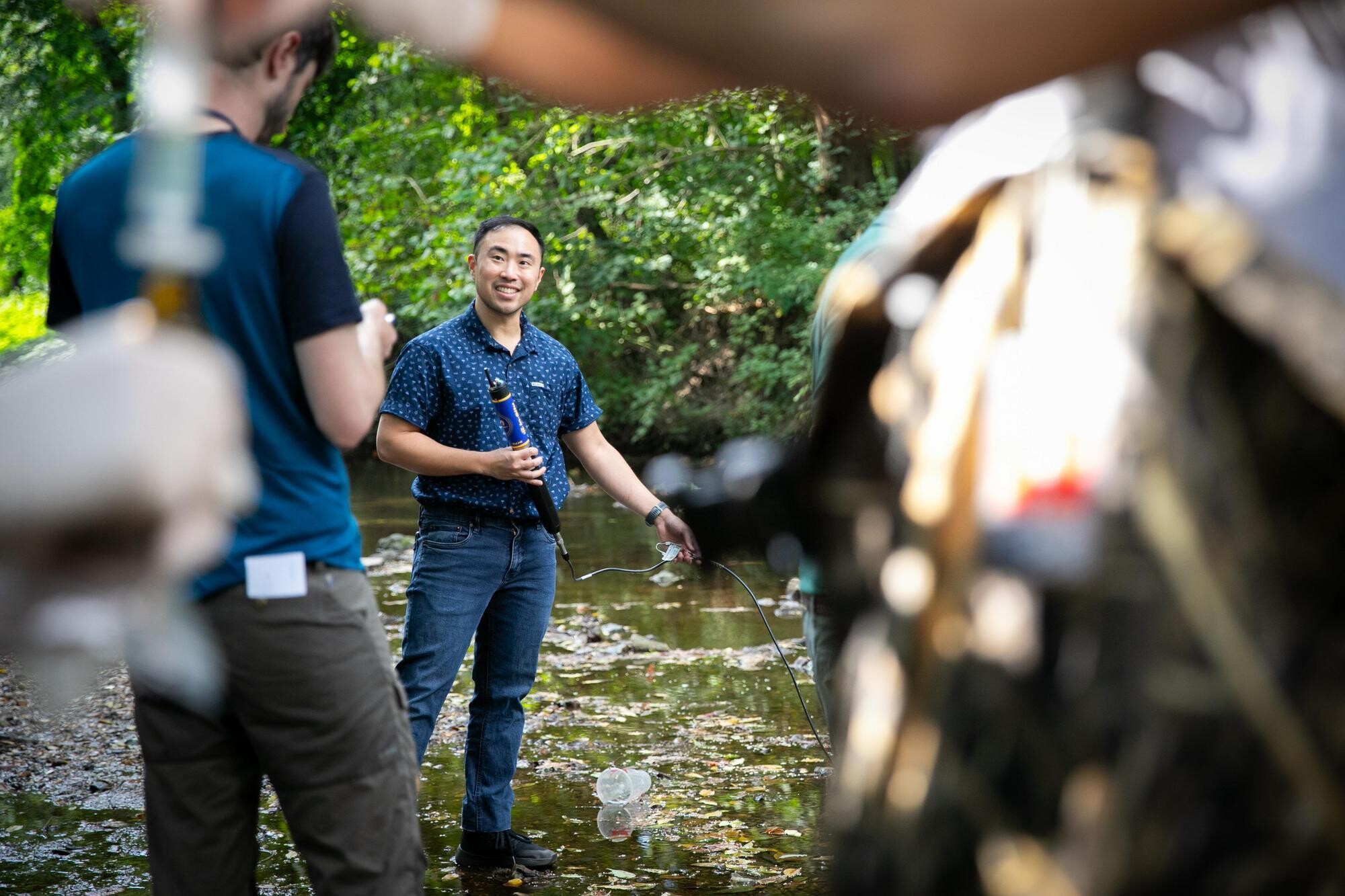 Two people taking water samples in Cobbs Creek.