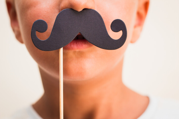 one-half of a child's face with a fake mustache