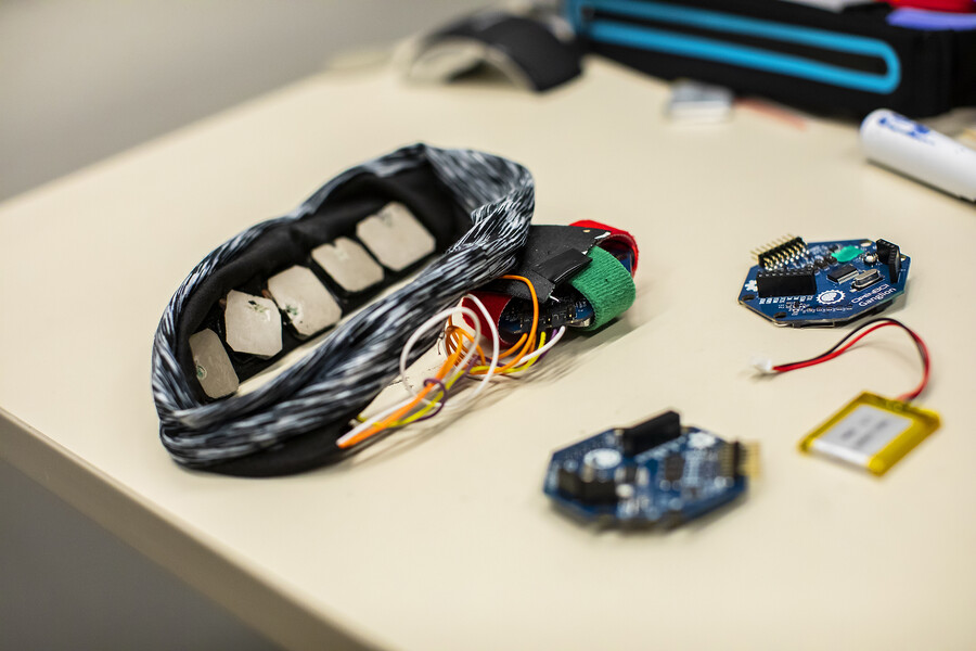Sensors, a head band, wires and a circuit board on a table. 