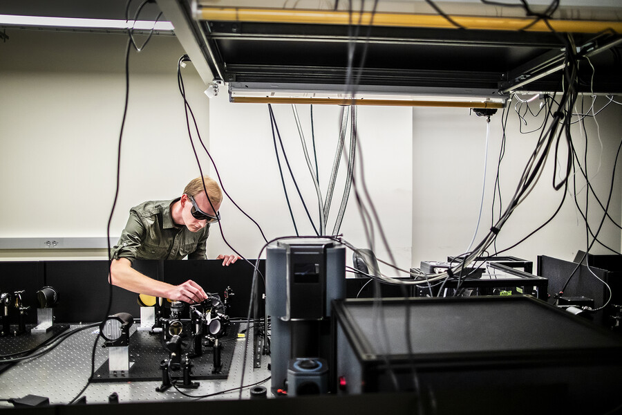 stensberg adjust a lens on top of an optics table