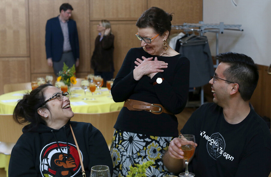 Christina Frei stands and greets seated members of the Gibson family 