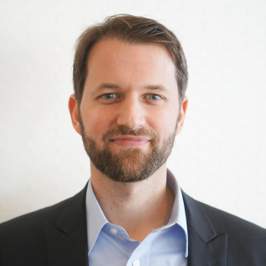 A headshot of a person wearing a suit. 