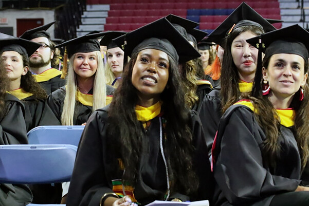Gianni Morsell seated in graduation robes at Commencement.