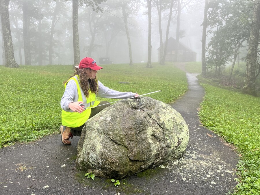 Jane Nasta measures a historic boulder drinking fountain at the Lewis Mountain campground.