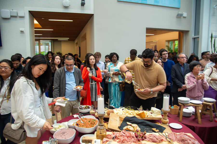 Visitors load their plates from a catered spread of meats, cheeses and salads at Perry World House.