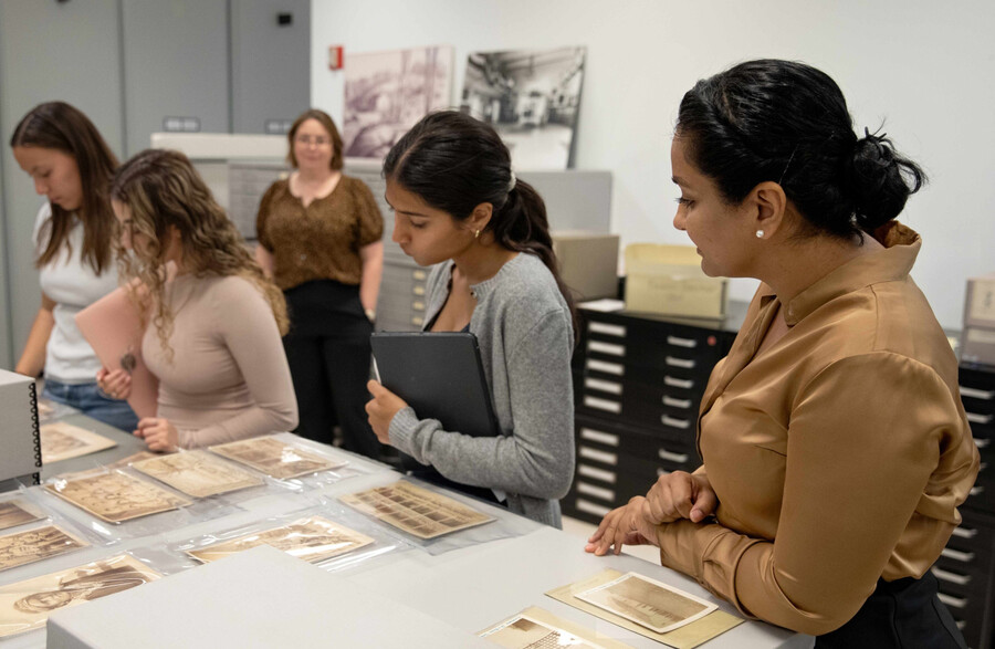 Dhillon Hardeep and students look at archival photographs.