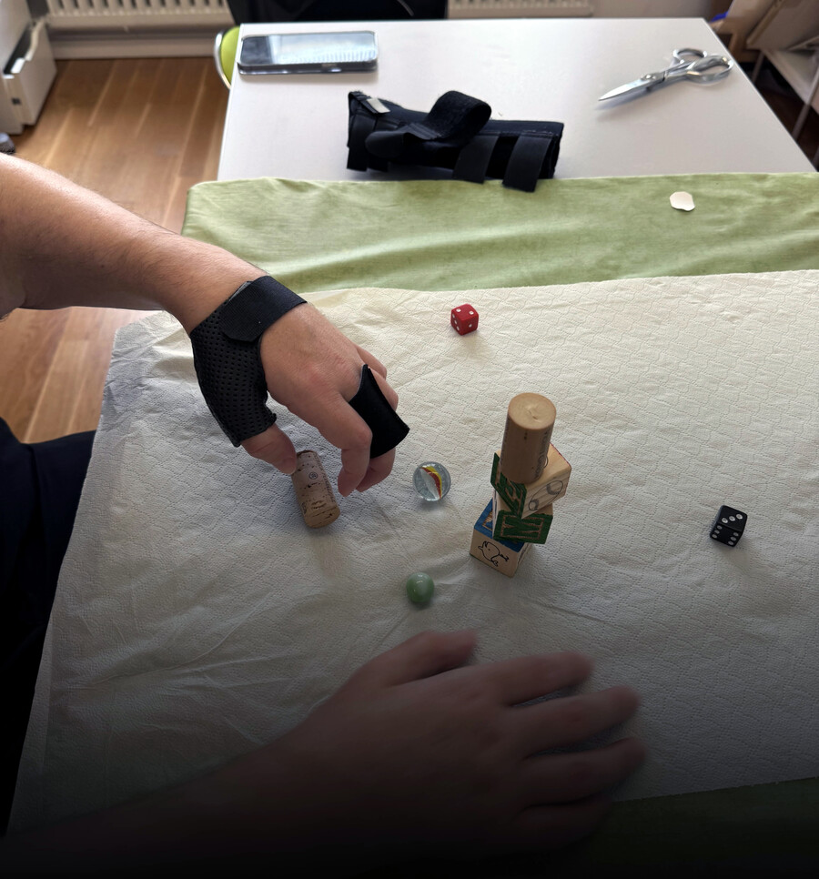 Luka Krizanac picking up small objects at physical therapy.