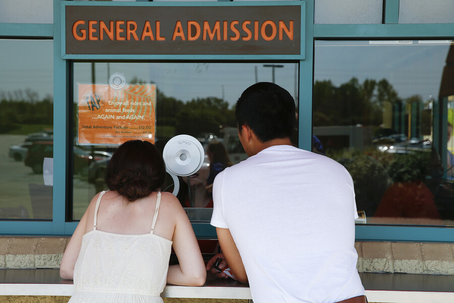 2 people buying tickets at a general admission window.