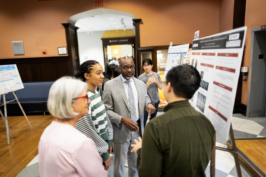 John Jackson interacts with students at an undergraduate research expo.