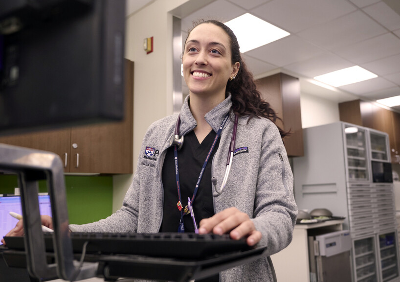 Julia Borgesi working at a standing computer desk.