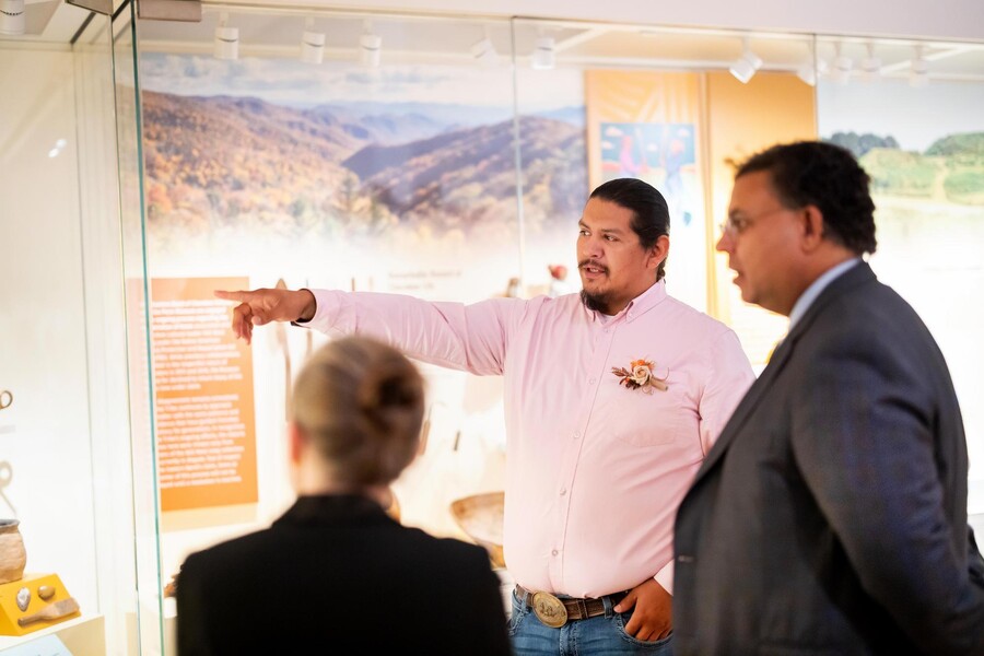 Three people looking at a display in Penn’s new Native North American Gallery.