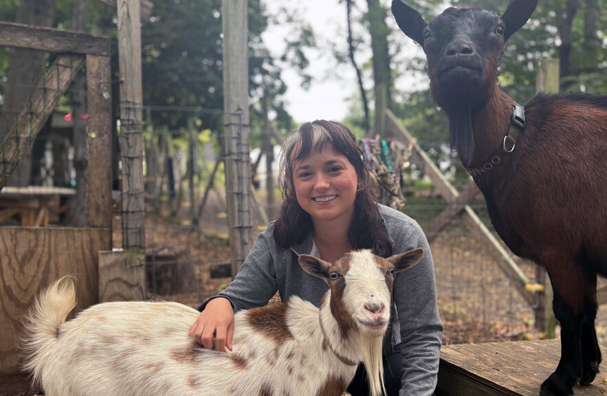Grace Freund with a goat from the Philly Goat Project.