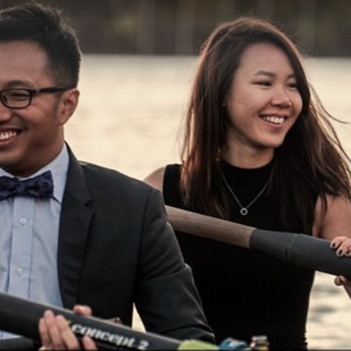 Young rowers paddling on river in formal attire