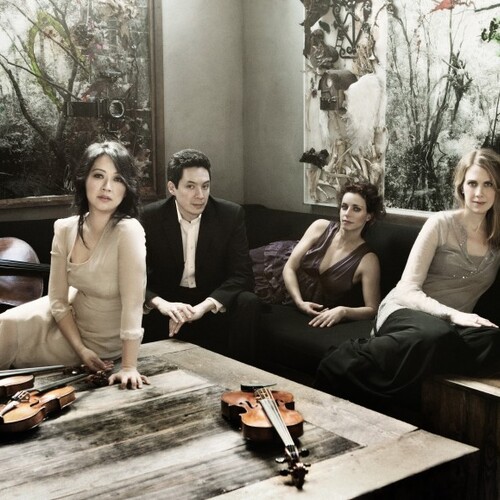 Musicians on a couch with violins and a cello