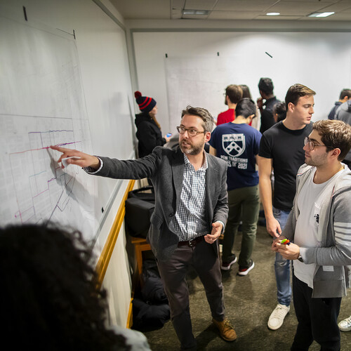 Penn history professor Brent Cebul working with students on wall maps. 