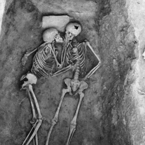 A skeleton kissing another skeleton in a grave