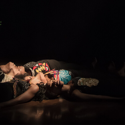 Women laying down together on stage floor
