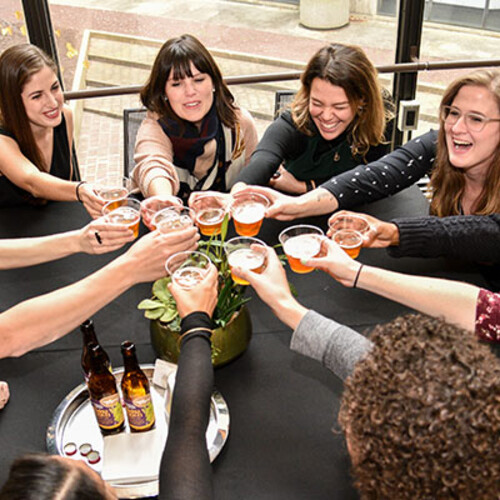 Group of people doing a cheers with beer