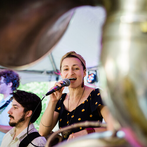 A performer from the West Philadelphia Orchestra sings into a mic