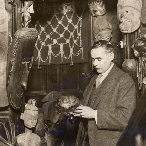 Man in suit examining archaeological objects from Africa