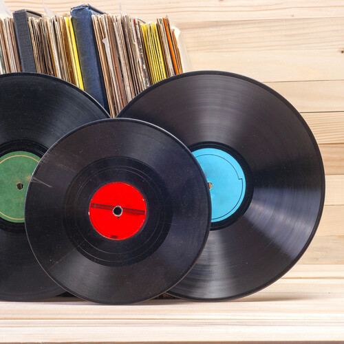 Vinyl records placed in front of a stack of sleeves