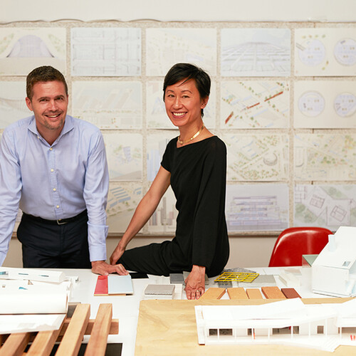 Eric and Mimi resting against table with schematics in background