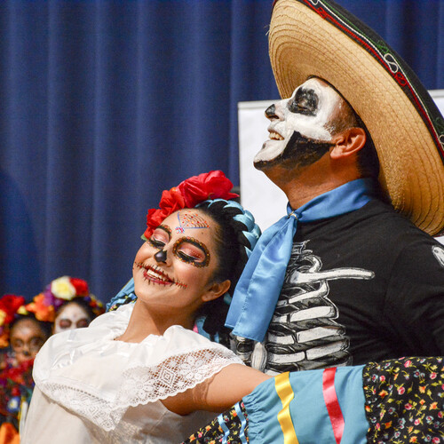 Two costumed dancers at a Dia de Los Muertos event