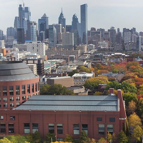 Aerial view of Huntsman Hall and the Philadelphia city skyline in daylight.
