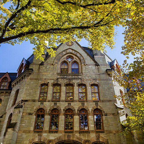 Facade of the Claudia Cohen Hall building in the sunlight.