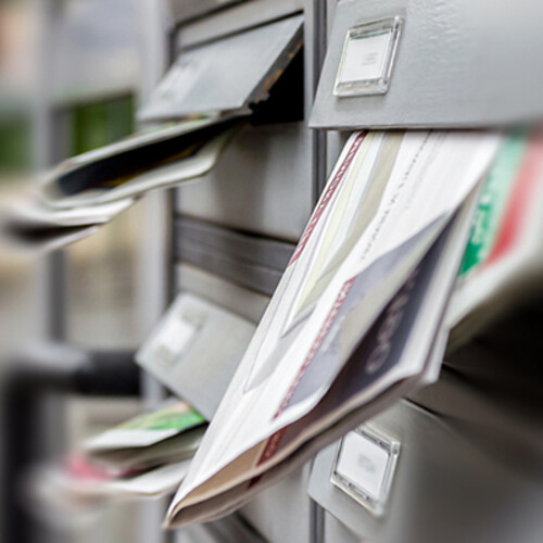Grey mail slots are full of letters and other post