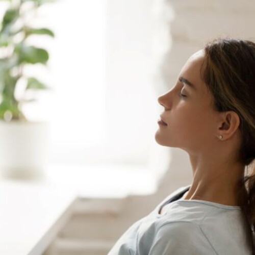 Woman meditating in sunlight