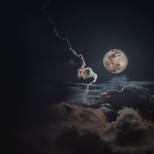 A full moon with clouds in the sky