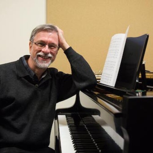 James Primosch smiling by the piano.