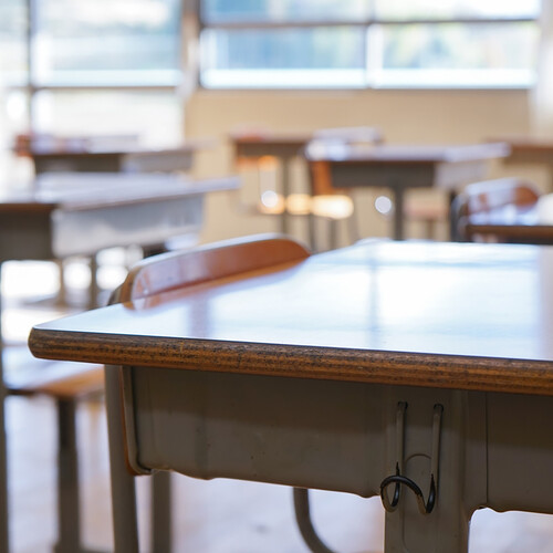 Empty desks in elementary school classroom.